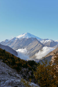 Scenic view of snowcapped mountains against clear blue sky