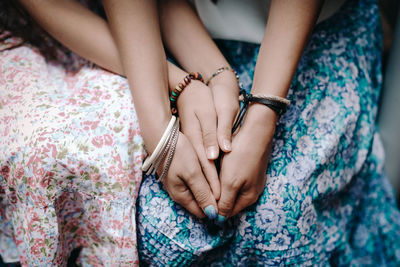 Hands of mom and daughter with boho bracelets. family and love concept