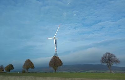 Windmill on field against sky