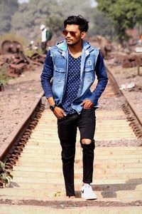 Young man standing on railroad track