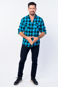 Portrait of young man standing against white background