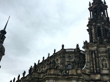 Low angle view of statues on building against sky