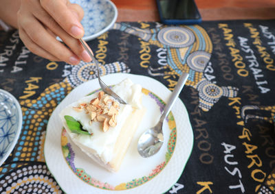 High angle view of hand holding ice cream on table