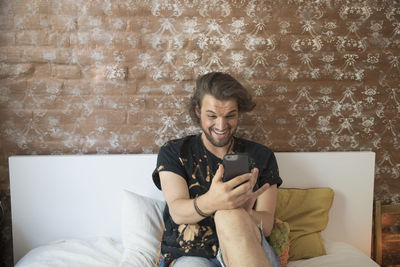 Young man taking a selfie on his bed