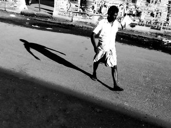 Full length of man skateboarding on road