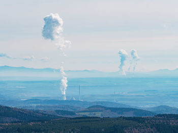 Smoking coal-fired power plant and steam cloud above cooling tower. ore mountains, czech republic