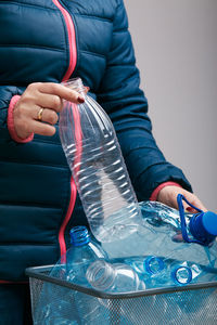 Woman holding trash bin with collected used plastic bottles and packagings. collecting plastic waste