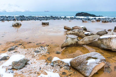 Rocks on beach against sky