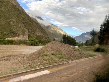 Road by mountains against sky