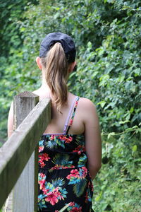 Rear view of woman standing against plants