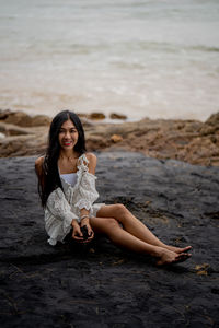 Portrait of young woman sitting on beach