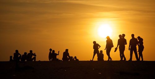 Silhouette people against sky during sunset