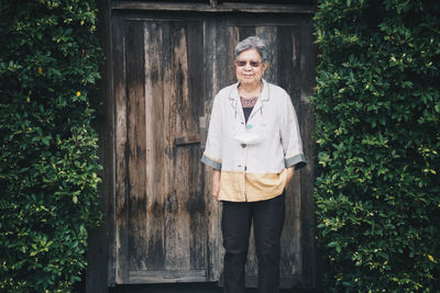 Portrait of woman standing against plants