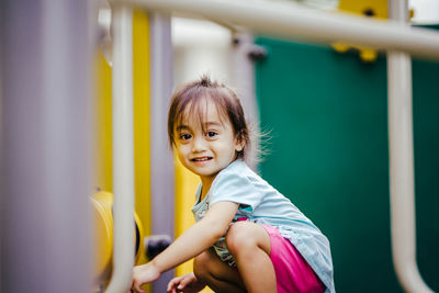 Portrait of smiling cute girl crouching at outdoors