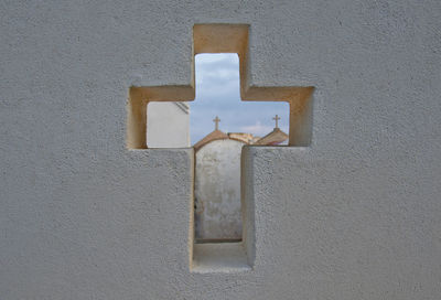 Church seen through cross on wall