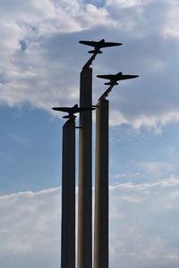 Low angle view of crane on pole against sky