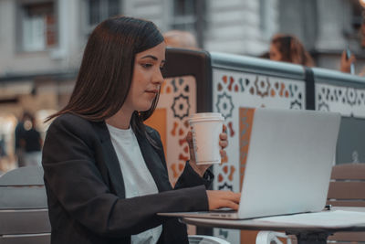 Young woman using laptop at table