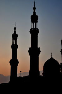 Silhouette built structure against sky during sunset