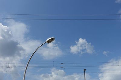 Low angle view of power lines against blue sky