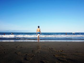 Man walking on shore at beach