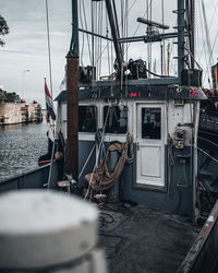 Sailboats moored on harbor in city against sky