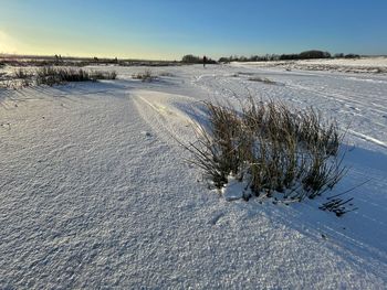 Scenic view of snow covered land against sky