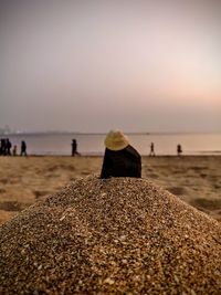 Close-up of pebbles on beach against sky during sunset