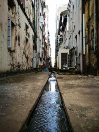 Wet city street against sky