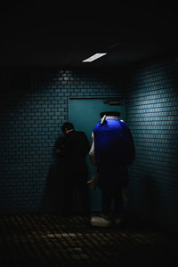 Rear view of man and woman in illuminated room