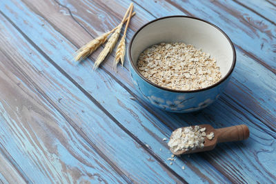 High angle view of oats flakes on in a bowl on table.