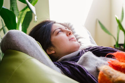 Woman relaxing on bean bag at home