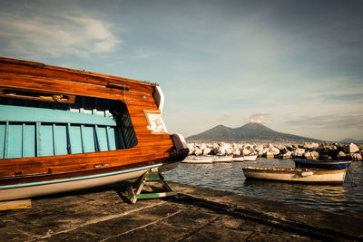 Boats moored on lake against sky