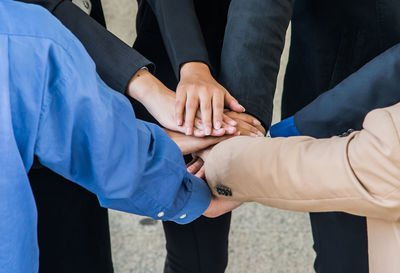 Cropped image of business people stacking hands