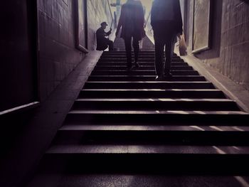 Low section of people walking by street musician on steps