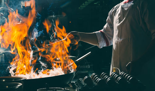 Chef stir fry busy cooking in kitchen. chef stir fry the food in a frying pan