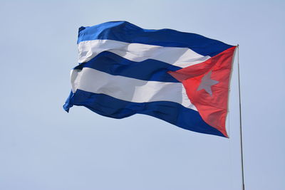 Low angle view of flag against blue sky