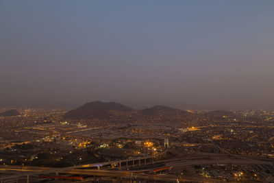 High angle view of illuminated cityscape against sky at sunset