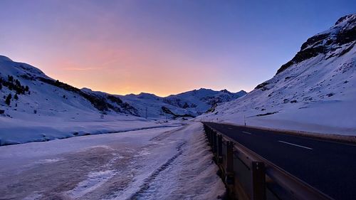 Road amidst snowcapped mountains against sky during winter