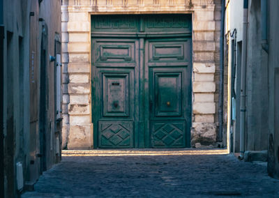 Large green door in an alley in the city of l'isle-sur-la-sorgue