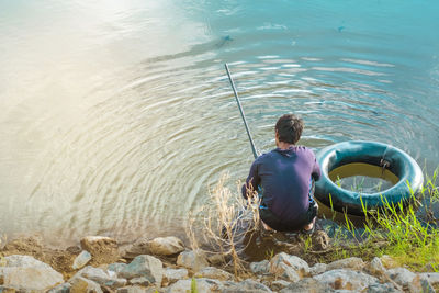 Rear view of man fishing in lake