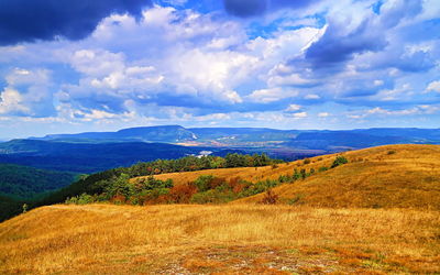 Scenic view of field and mountains against sky