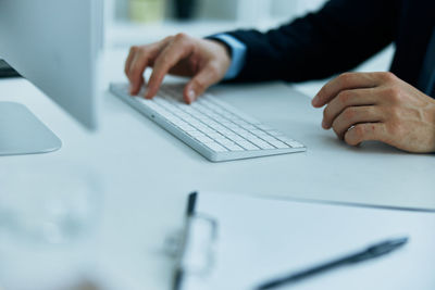 Midsection of man using smart phone on table