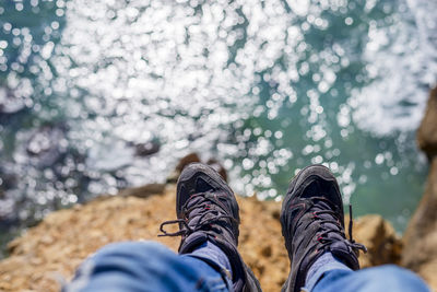 Low section of hiker sitting on mountain