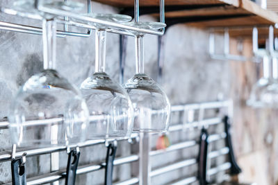 Close-up of wineglasses hanging against wall