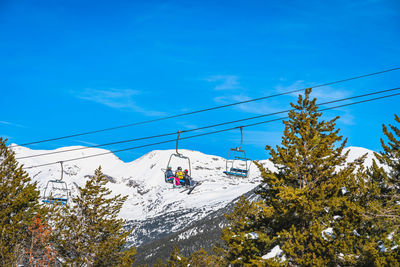 Group of skiers riding up on chair ski lift in andorra, pyrenees mountains