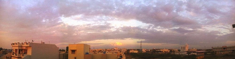 Buildings in city against cloudy sky