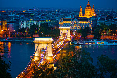 Illuminated bridge over river at night