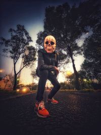 Full length portrait of child on tree against sky