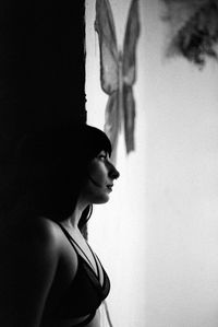 Portrait of woman standing against wall at home