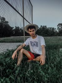 Portrait of man sitting on field